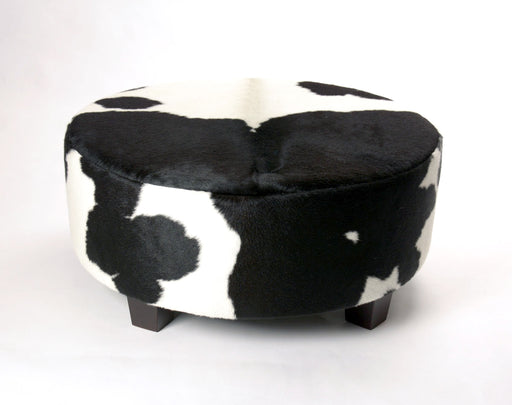 A beautiful bkack and white round cowhide ottoman